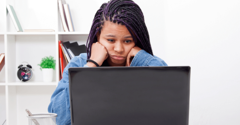 The girl looks stressed in front of her computer